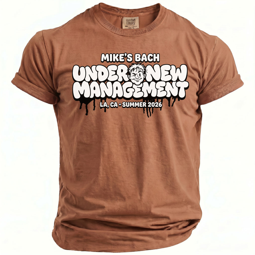 Brown t-shirt with "MIKE'S BACH UNDER NEW MANAGEMENT" text and cartoon.
