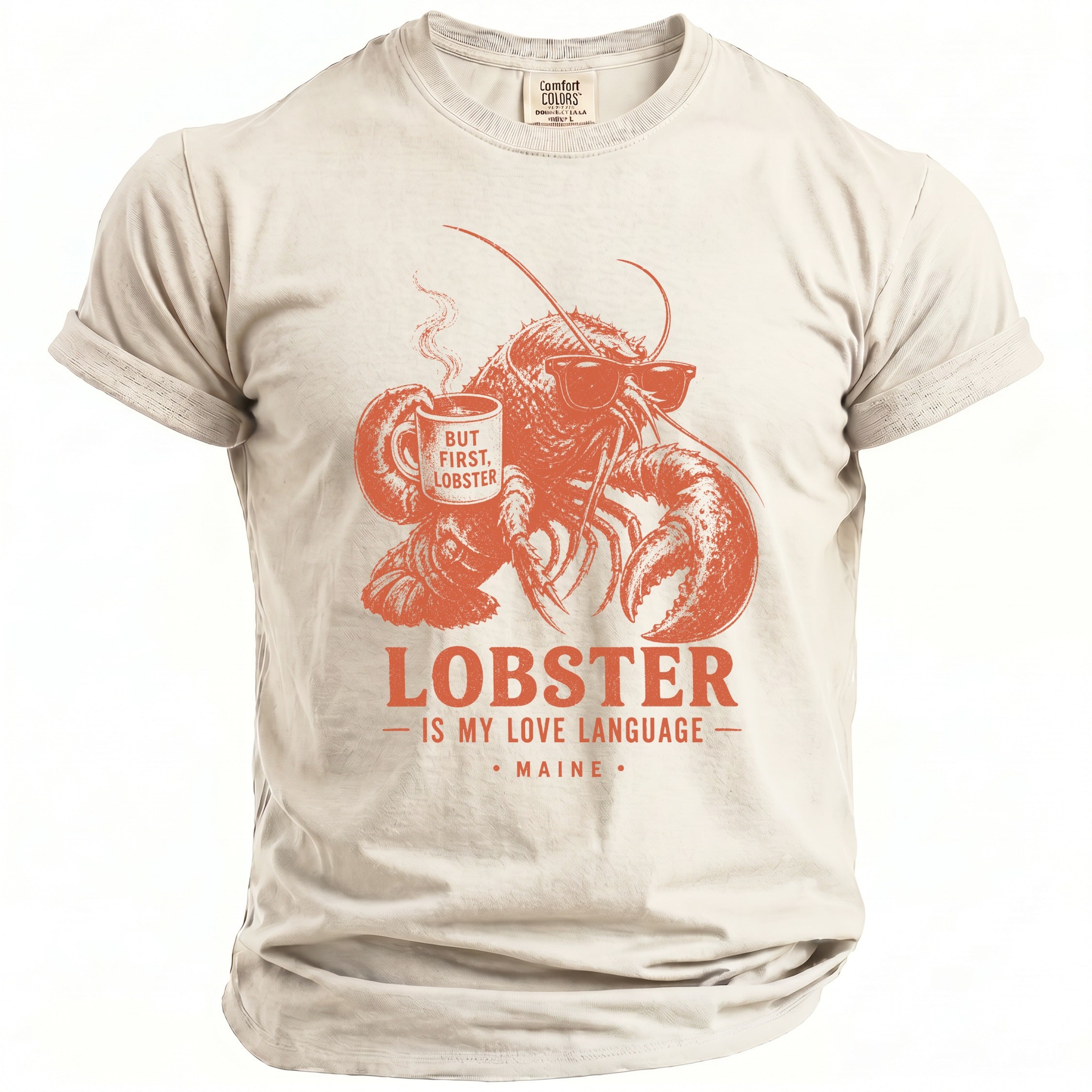 Cream t-shirt with orange graphic of lobster drinking coffee, text reads "But First, Lobster," "Lobster is my Love Language," and "Maine."