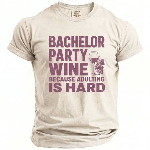 Light tan t-shirt with purple text "Bachelor Party Wine Because Adulting Is Hard" and wine glass graphic.