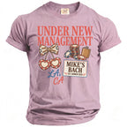 Lavender graphic t-shirt with "UNDER NEW MANAGEMENT" and "MIKE'S BACH" designs.