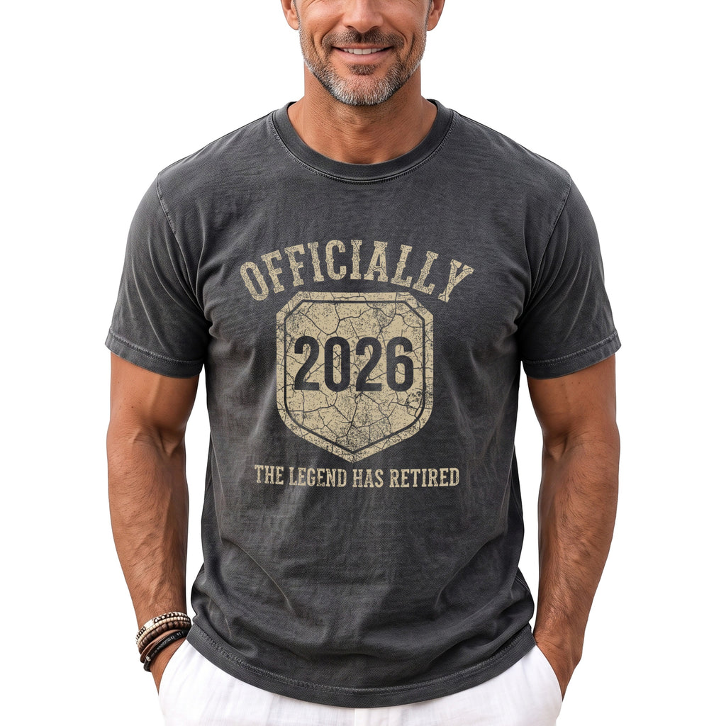 Dark grey t-shirt with "Officially 2026 The Legend Has Retired" text and shield graphic.