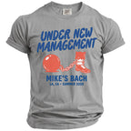 Grey t-shirt with "UNDER NEW MANAGEMENT MIKE'S BACH LA, CA SUMMER 2026" and ball and chain design.