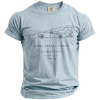 Light blue t-shirt with line art of a convertible car, house, and trees, and text.