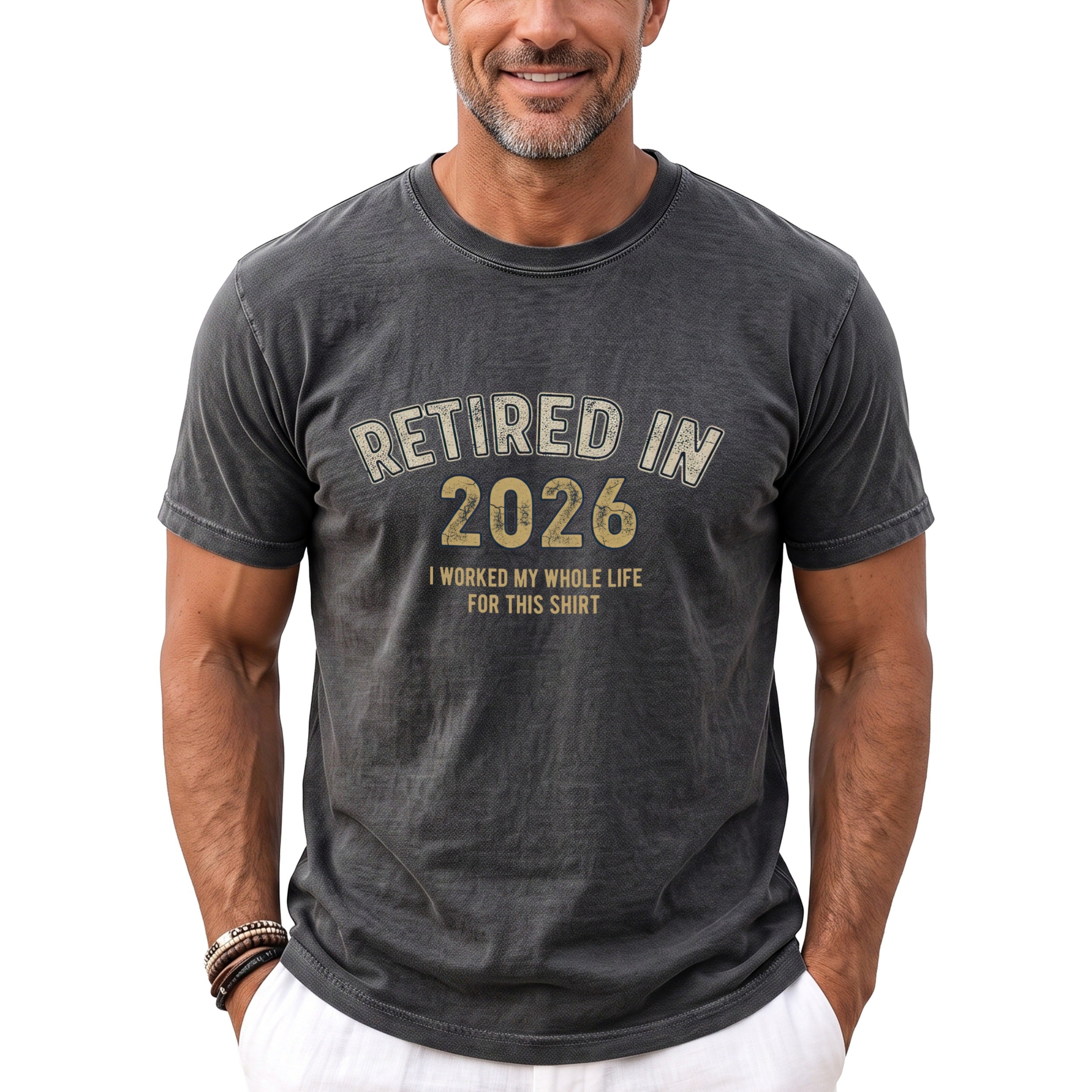 Dark gray t-shirt with "RETIRED IN 2026 I WORKED MY WHOLE LIFE FOR THIS SHIRT" text.