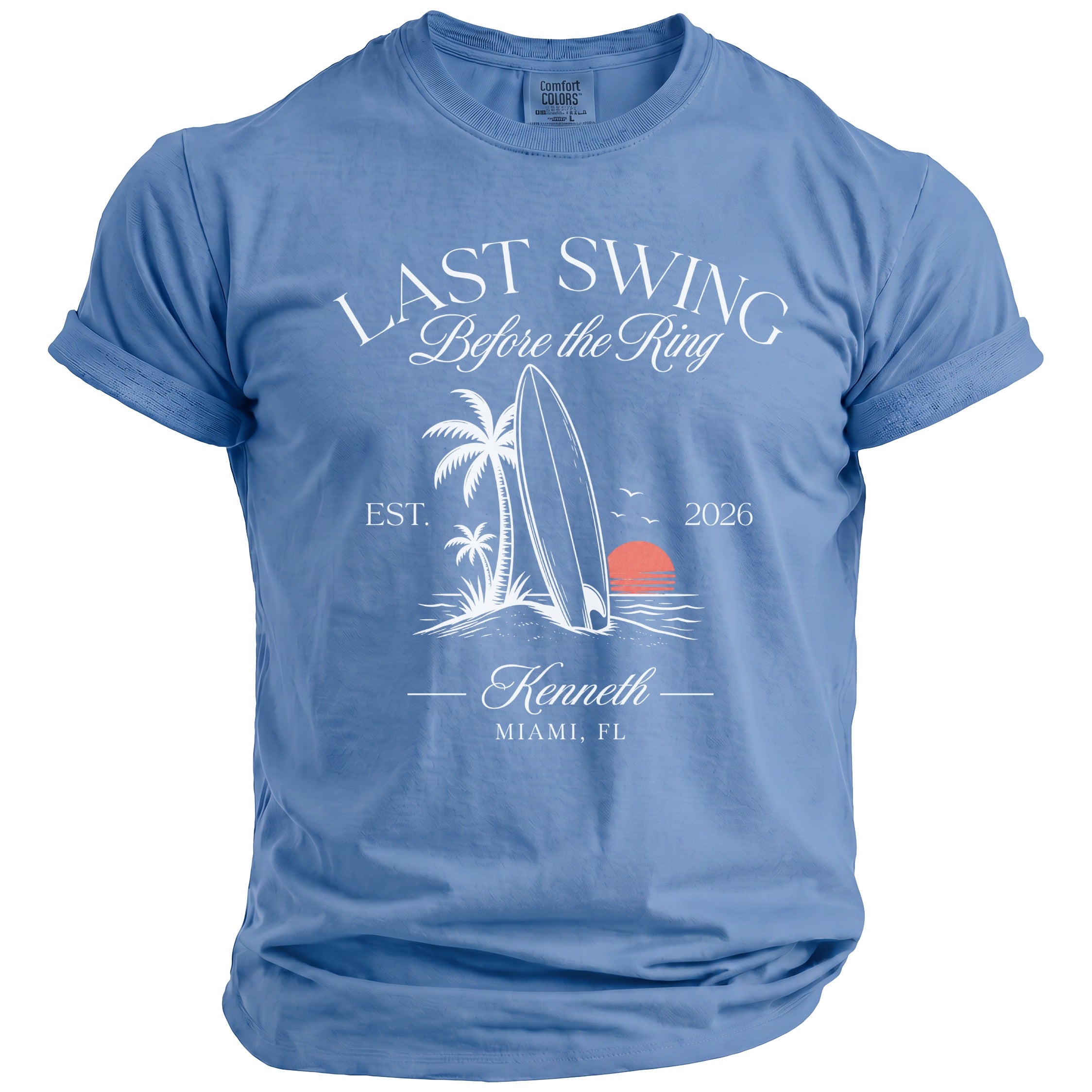 Blue t-shirt with "Last Swing Before the Ring" graphic featuring a surfboard, palm trees, and sunset.