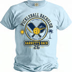 Light blue t-shirt with "Pickleball Bachelor" design and "Garrett's Bach 26" in yellow and navy.
