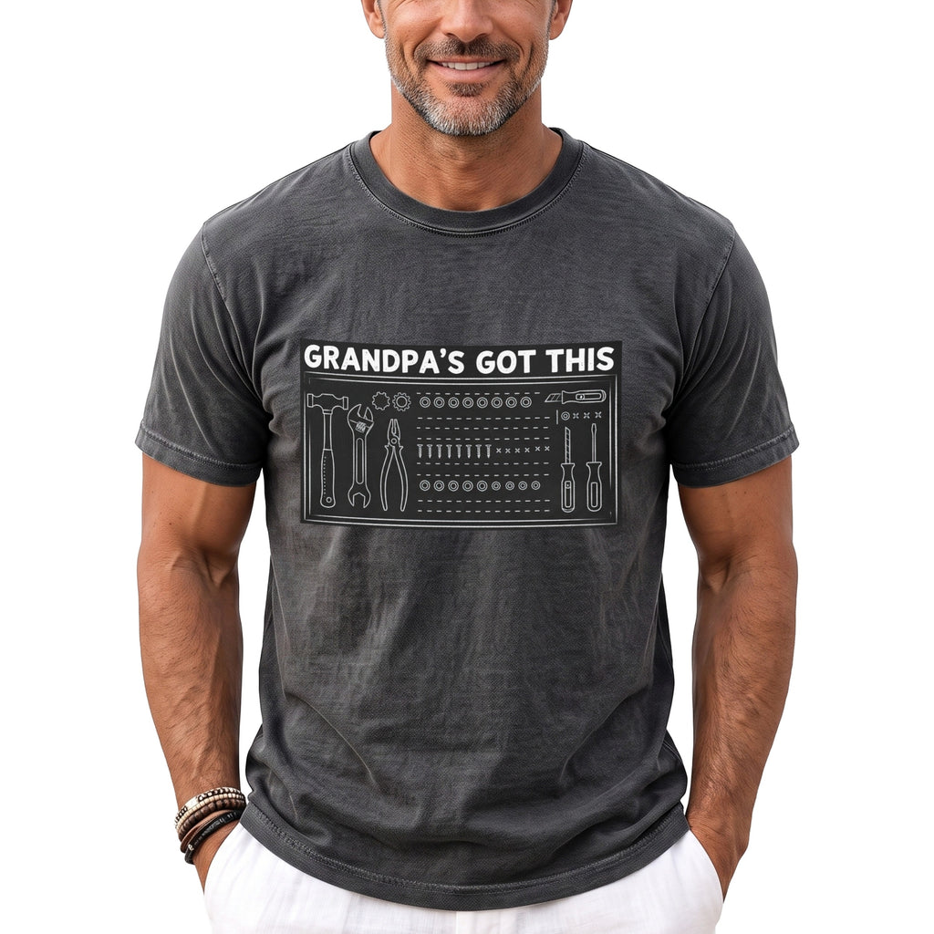 Dark grey t-shirt with white text "GRANDPA'S GOT THIS" and toolbox graphic.