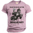 Pink t-shirt with a dragon in a suit holding cards and a drink, text reads "Rolling the dice one last time, Bachelor Party".