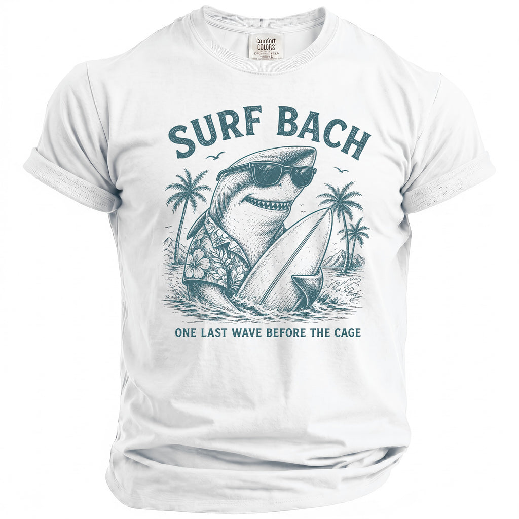 White t-shirt with a drawing of a shark in sunglasses holding a surfboard, with text "SURF BACH".