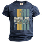 Navy t-shirt with "Bachelor Beach Club Groom's Beach Weekend 2026" graphic.