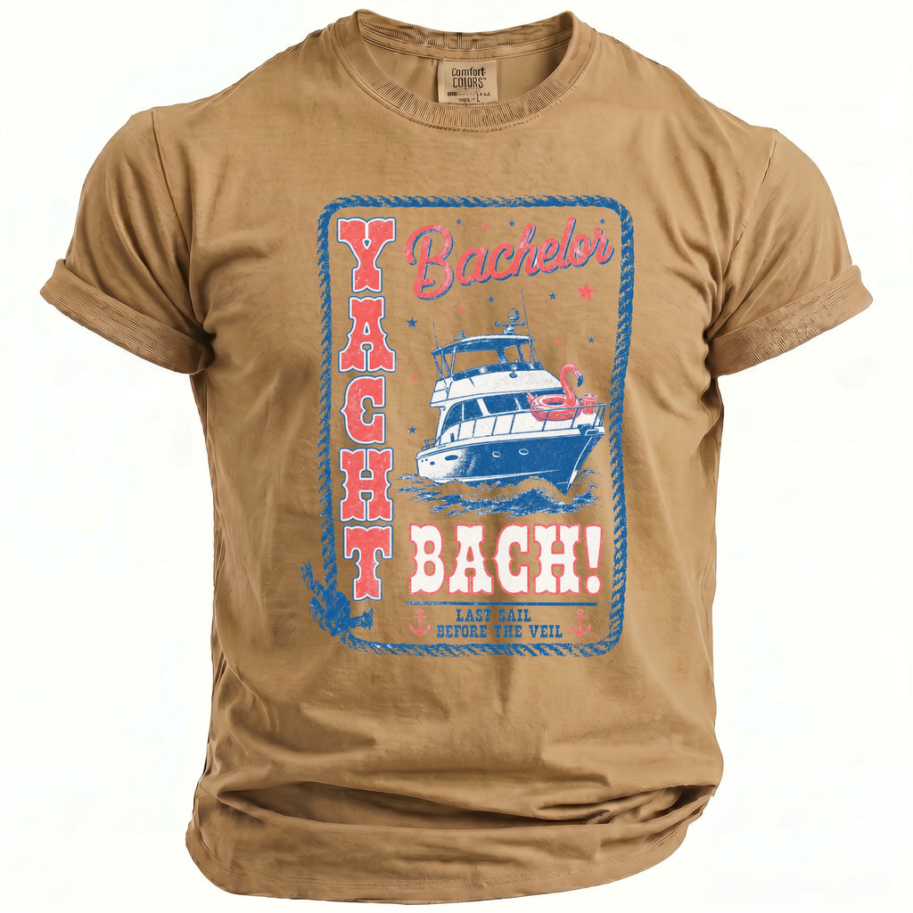 Tan short-sleeved t-shirt with a blue and red graphic featuring a yacht and text reading "Yacht Bach!".