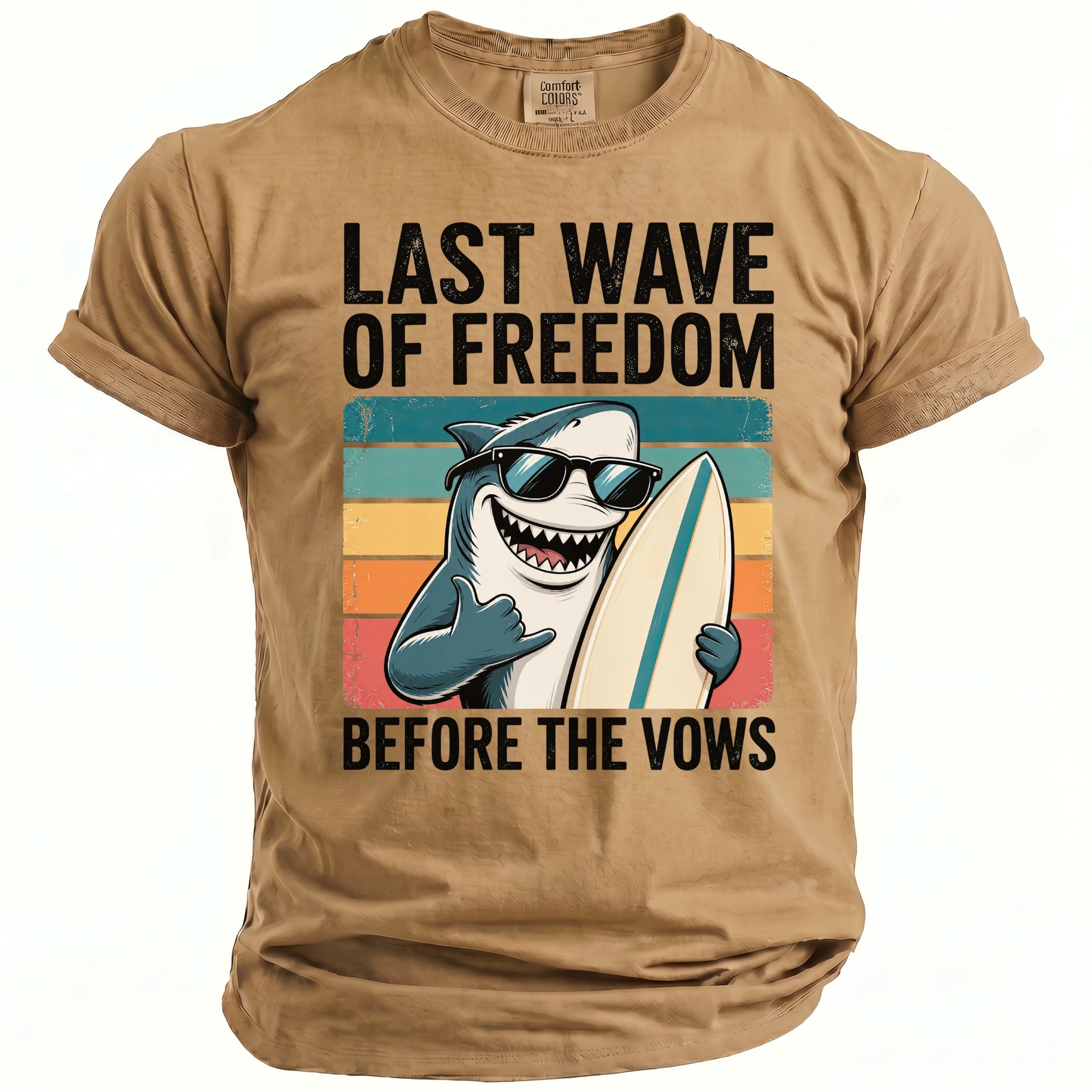 Tan t-shirt with shark wearing sunglasses holding surfboard and text "LAST WAVE OF FREEDOM BEFORE THE VOWS".
