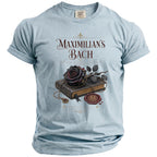 Light blue t-shirt with "Maximilian's Bach" and a dark rose on a book.