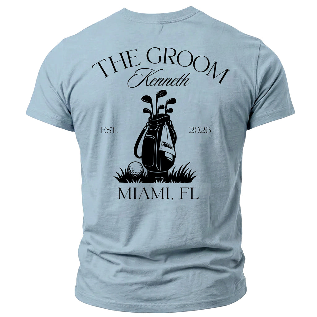 Light blue t-shirt with "THE GROOM Kenneth EST. 2026" above a golf bag graphic and "MIAMI, FL" below.