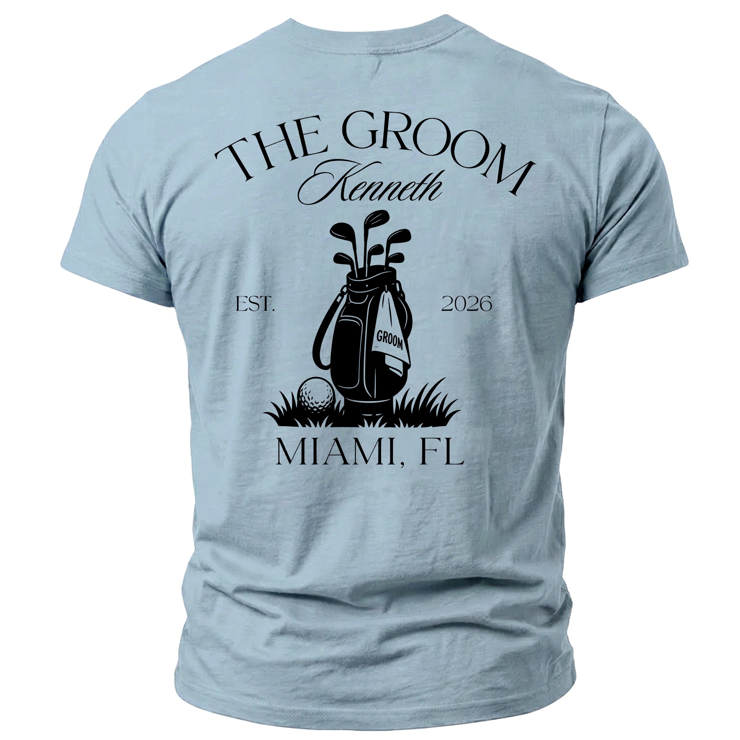 Light blue t-shirt with "THE GROOM Kenneth EST. 2026" above a golf bag graphic and "MIAMI, FL" below.