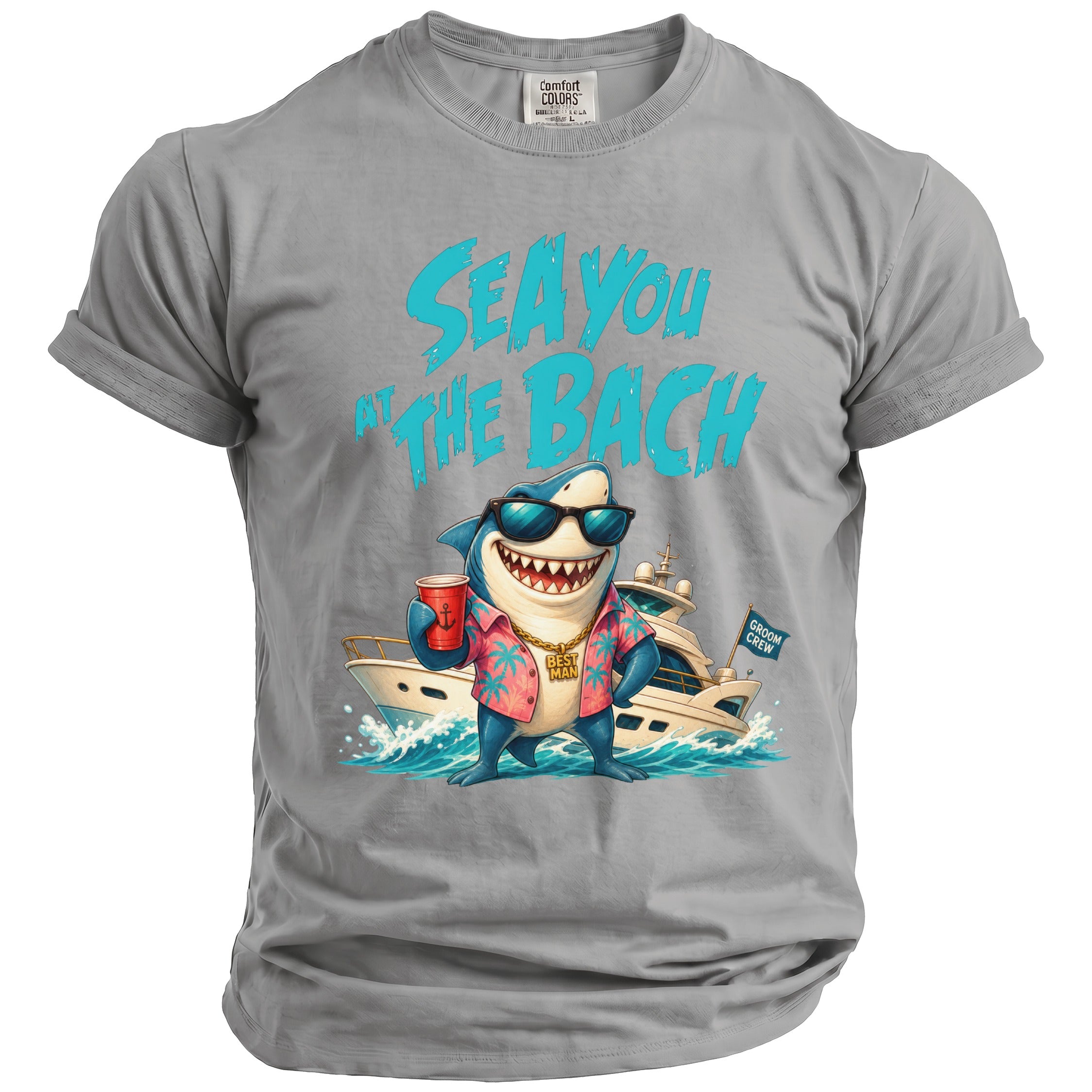 Grey t-shirt featuring a graphic of a shark wearing sunglasses, a floral shirt, and holding a red cup in front of a yacht, with the text "SEA YOU AT THE BACH".