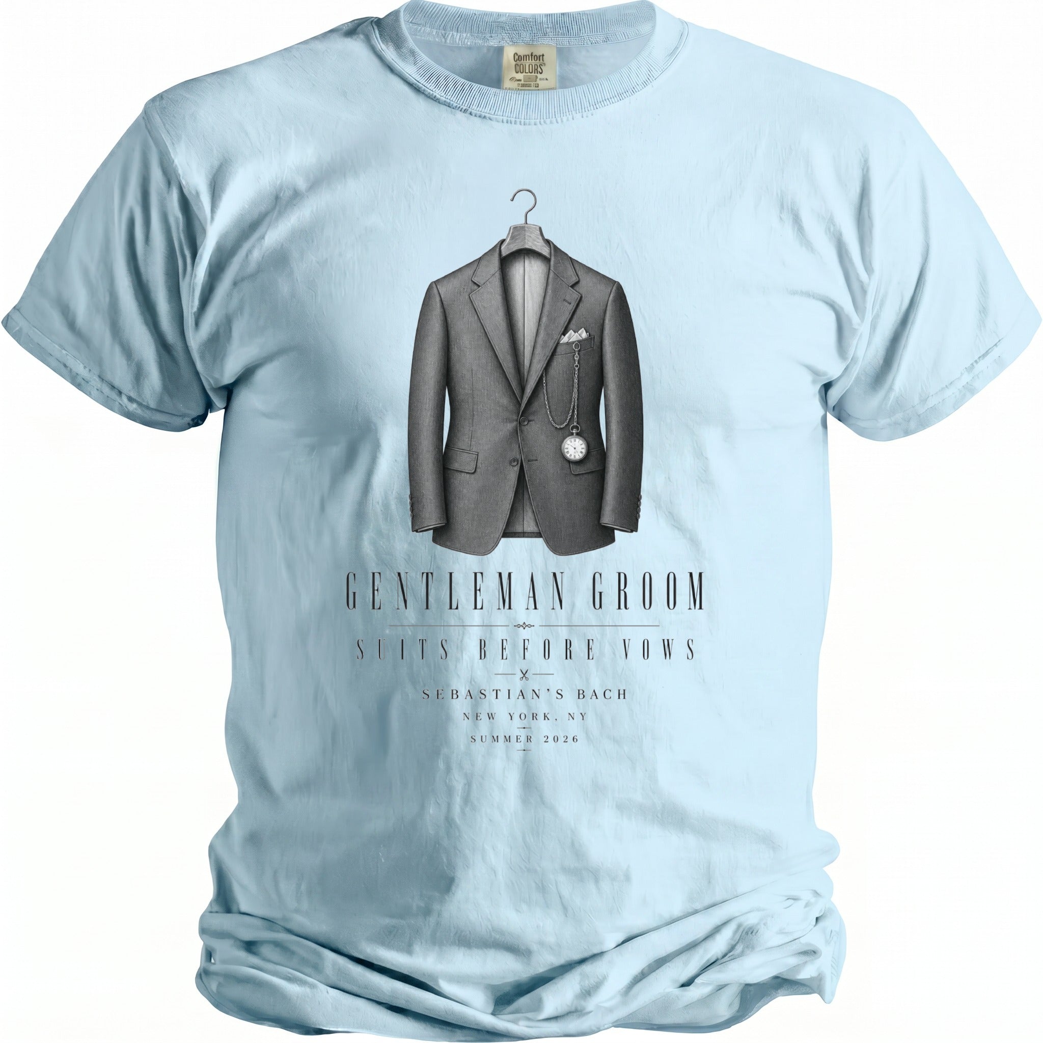 Light blue t-shirt with a graphic of a grey suit, pocket watch, and text: "GENTLEMAN GROOM SUITS BEFORE VOWS SEBASTIAN'S BACH".