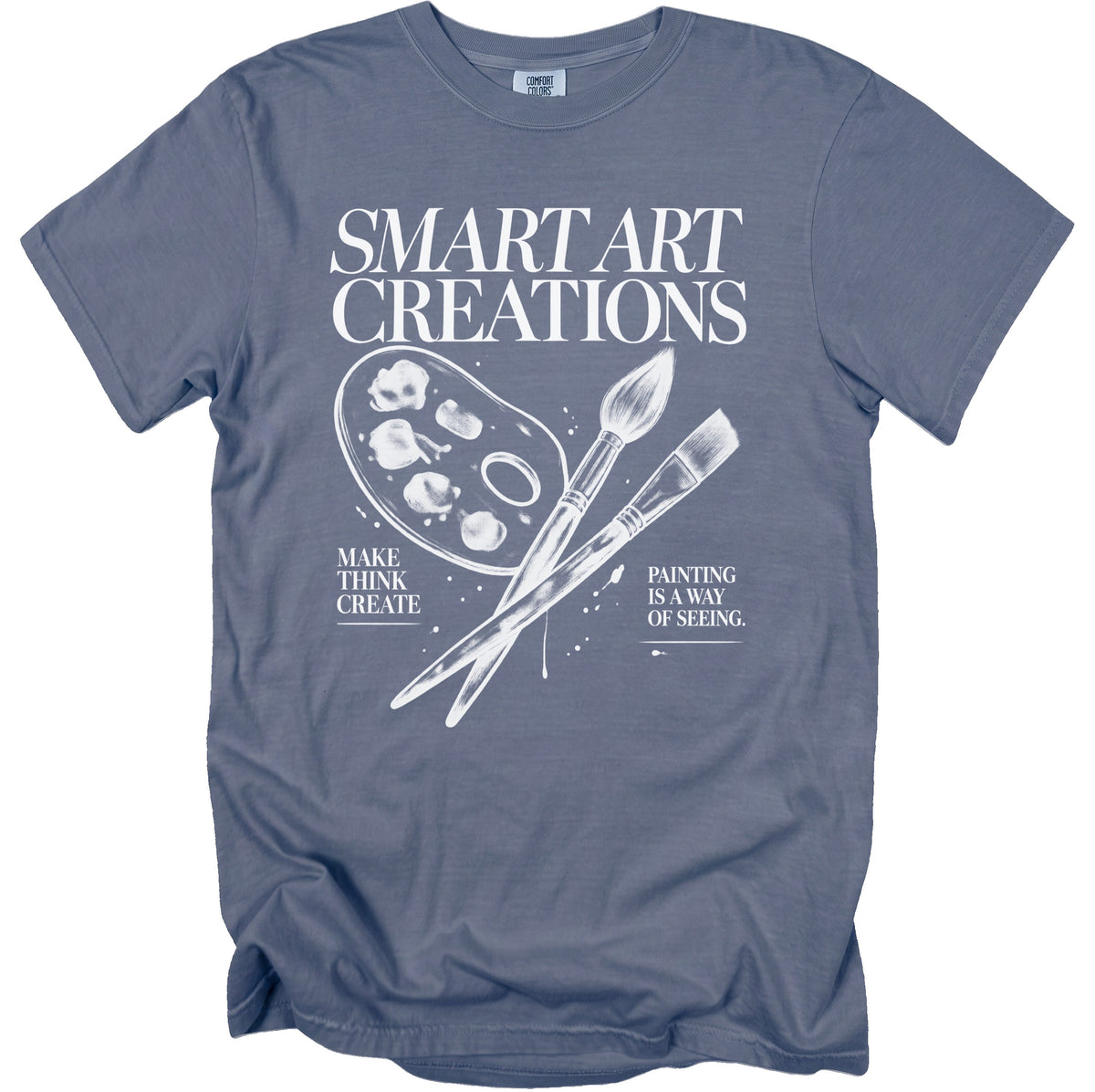 Blue t-shirt with white text and art supplies illustration.