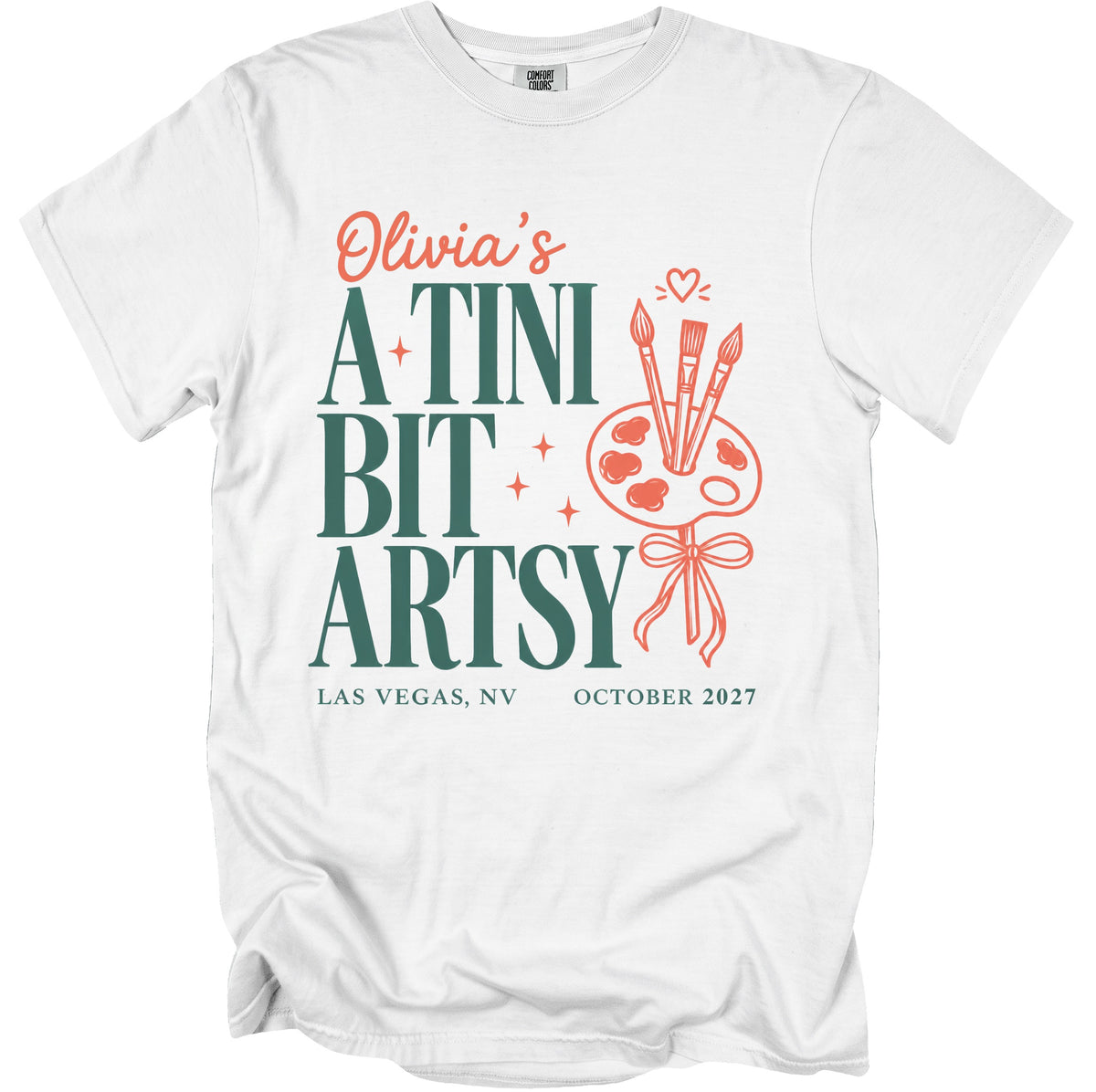 White t-shirt with "Olivia's A Tini Bit Artsy" text, paint palette, and brushes.