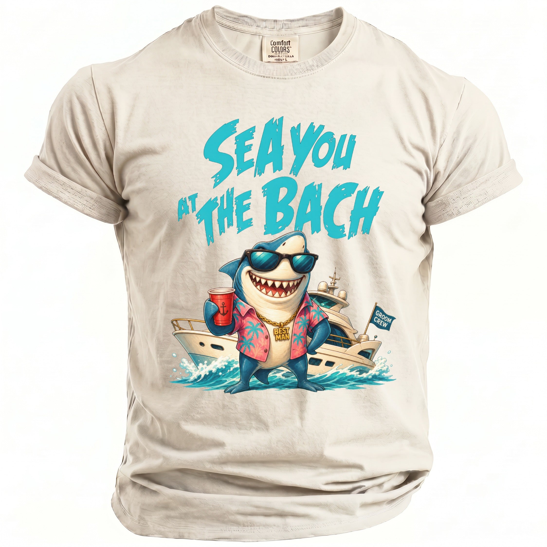 Off-white crewneck t-shirt featuring a graphic of a cartoon shark wearing sunglasses, a shirt, and holding a red cup in front of a yacht, with the text SEA YOU AT THE BACH above.