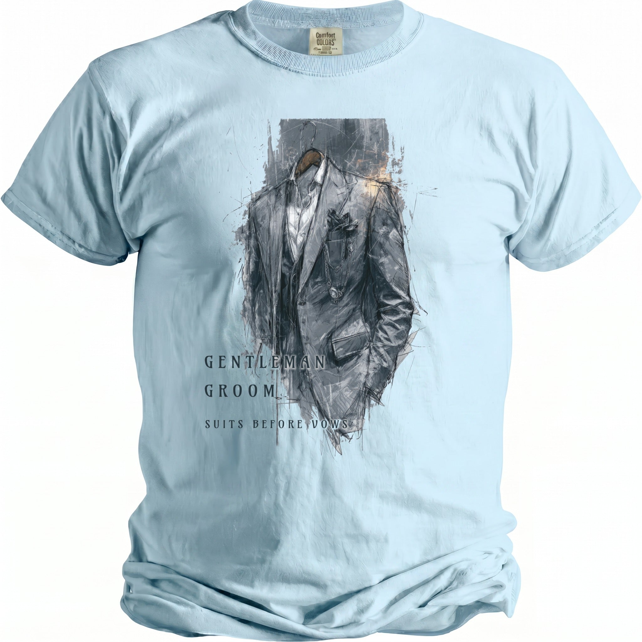 Light blue t-shirt with a sketched grey suit design and text reading "GENTLEMAN GROOM SUITS BEFORE VOWS".