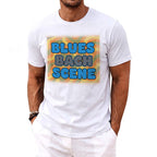 White t-shirt with blue and grey text reading "BLUES BACH SCENE" on a colorful background.