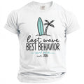 White t-shirt with surfboard, palm tree, and text "last wave BEST BEHAVIOR surf bach est. 2026".