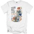 White t-shirt with "still life, still wild." text and floral art.