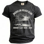 Dark grey t-shirt with "Bachelor Beach Club Groom's Last Wave 2026" graphic.
