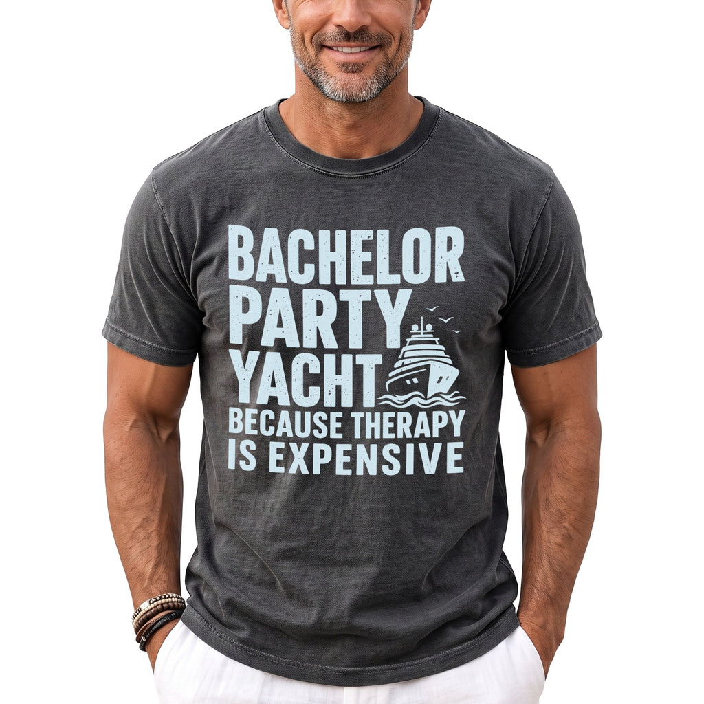 Dark gray t-shirt with light blue text "BACHELOR PARTY YACHT BECAUSE THERAPY IS EXPENSIVE" and a yacht graphic.