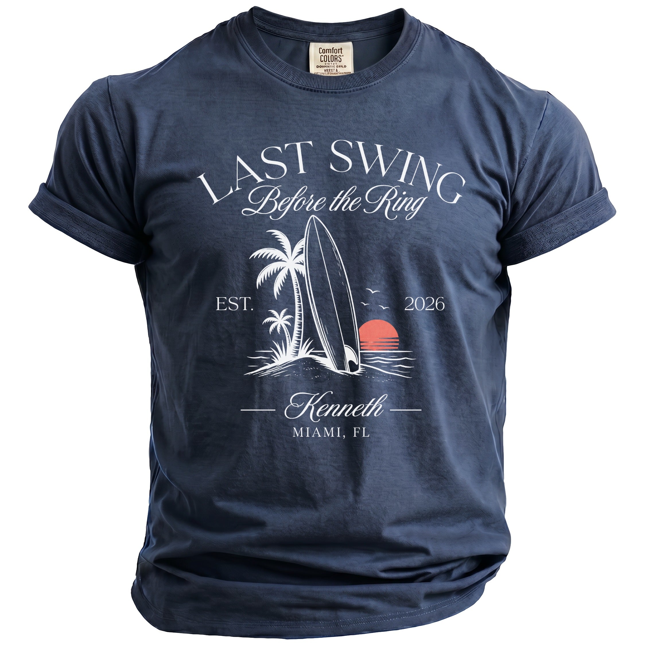 Navy t-shirt with "Last Swing Before the Ring" design, featuring a surfboard, palm trees, and sunset.