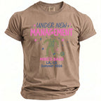 Brown t-shirt with graphic "Under New Management" and man in suit chained to ball.