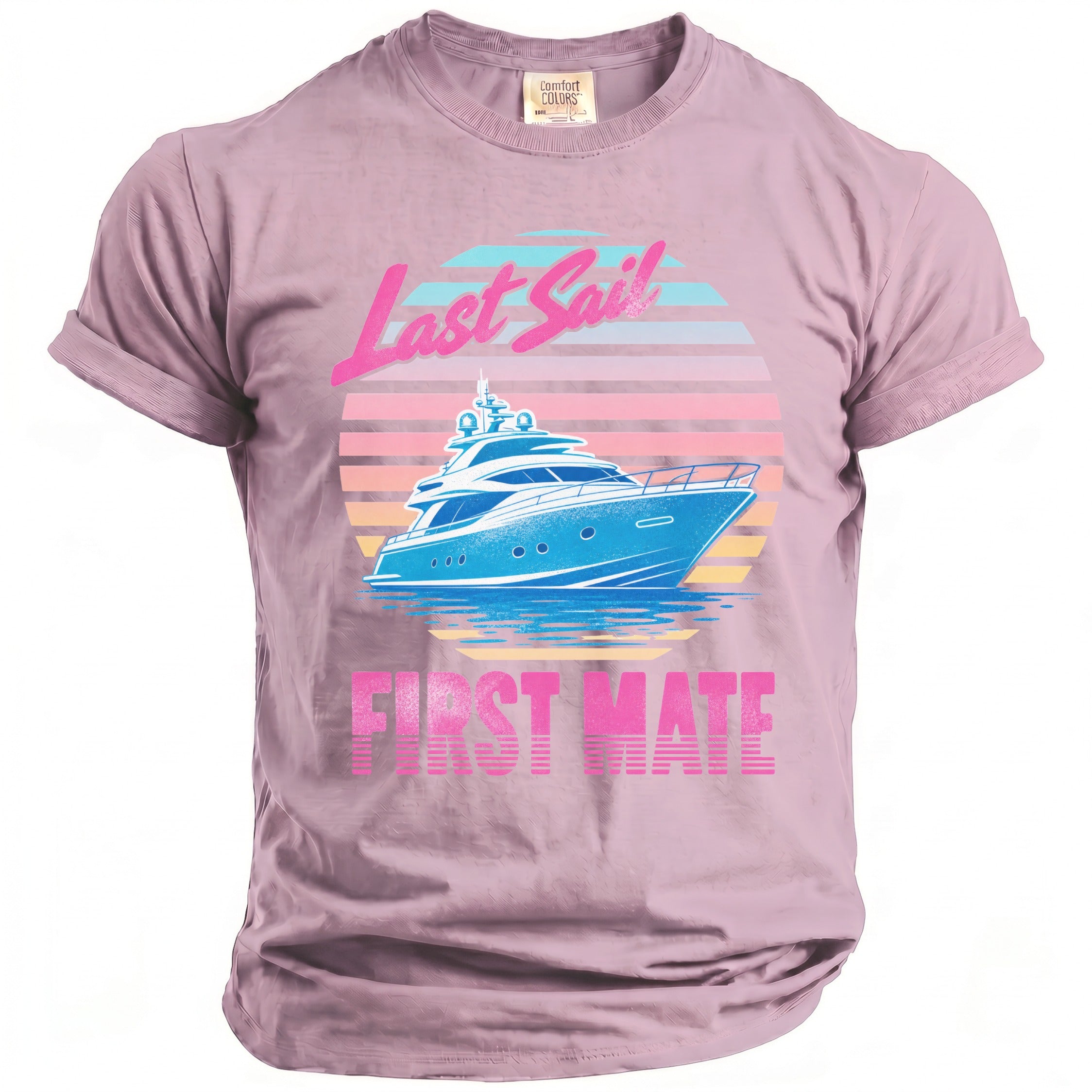 A dusty pink t-shirt featuring a retro-style graphic of a blue yacht against a striped sunset and the text "Last Sail First Mate."