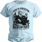 Light blue t-shirt with a dragon in a suit holding a whiskey glass, "Bachelor Party" text.