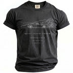 Black t-shirt with white graphic: car, house, foliage, and text.