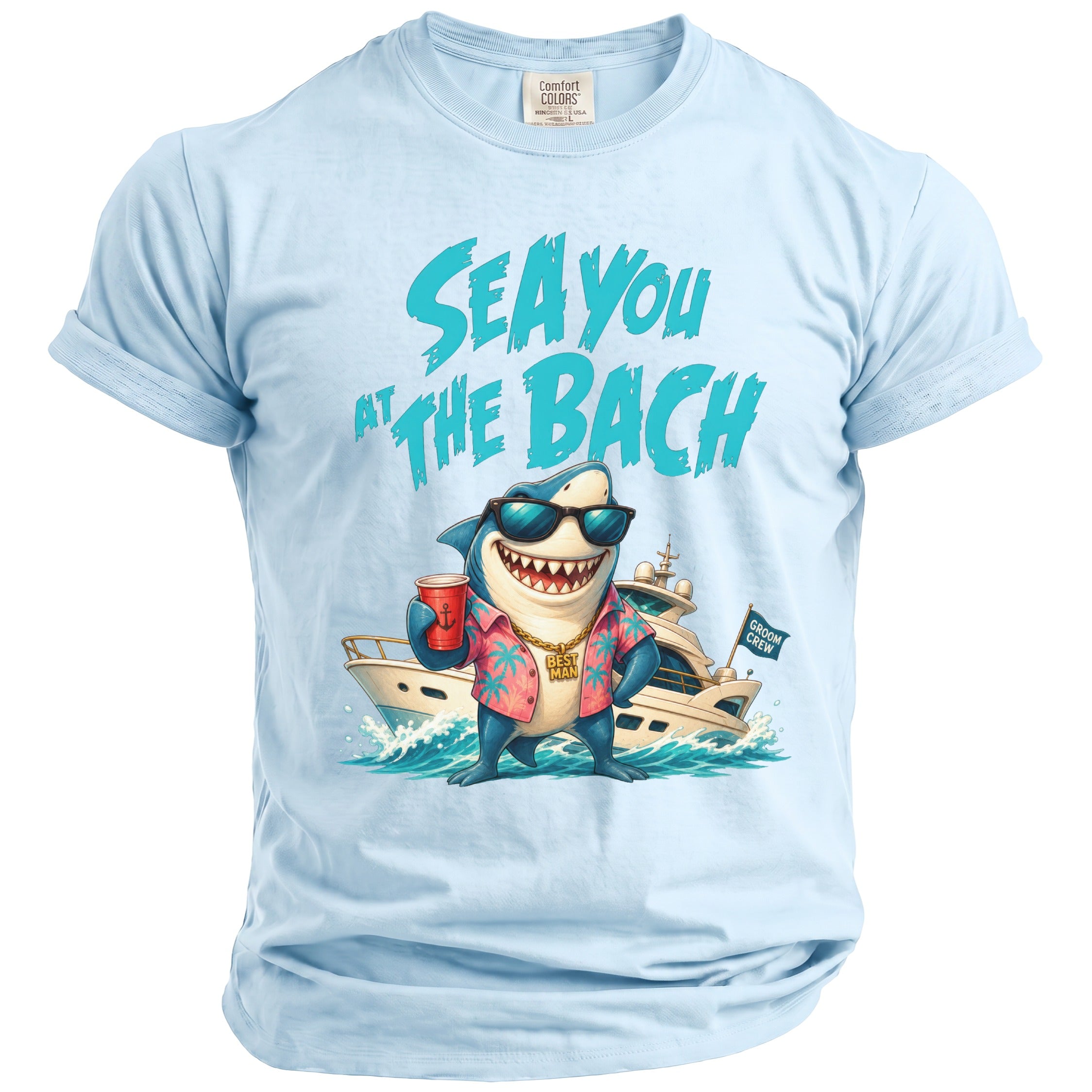 A light blue crewneck t-shirt featuring graphic art of a shark wearing sunglasses and a tropical shirt in front of a yacht, with the text SEA YOU AT THE BACH.
