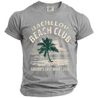 Grey t-shirt with "BACHELOR BEACH CLUB GROOM'S LAST WAVE 2026" and palm tree design.