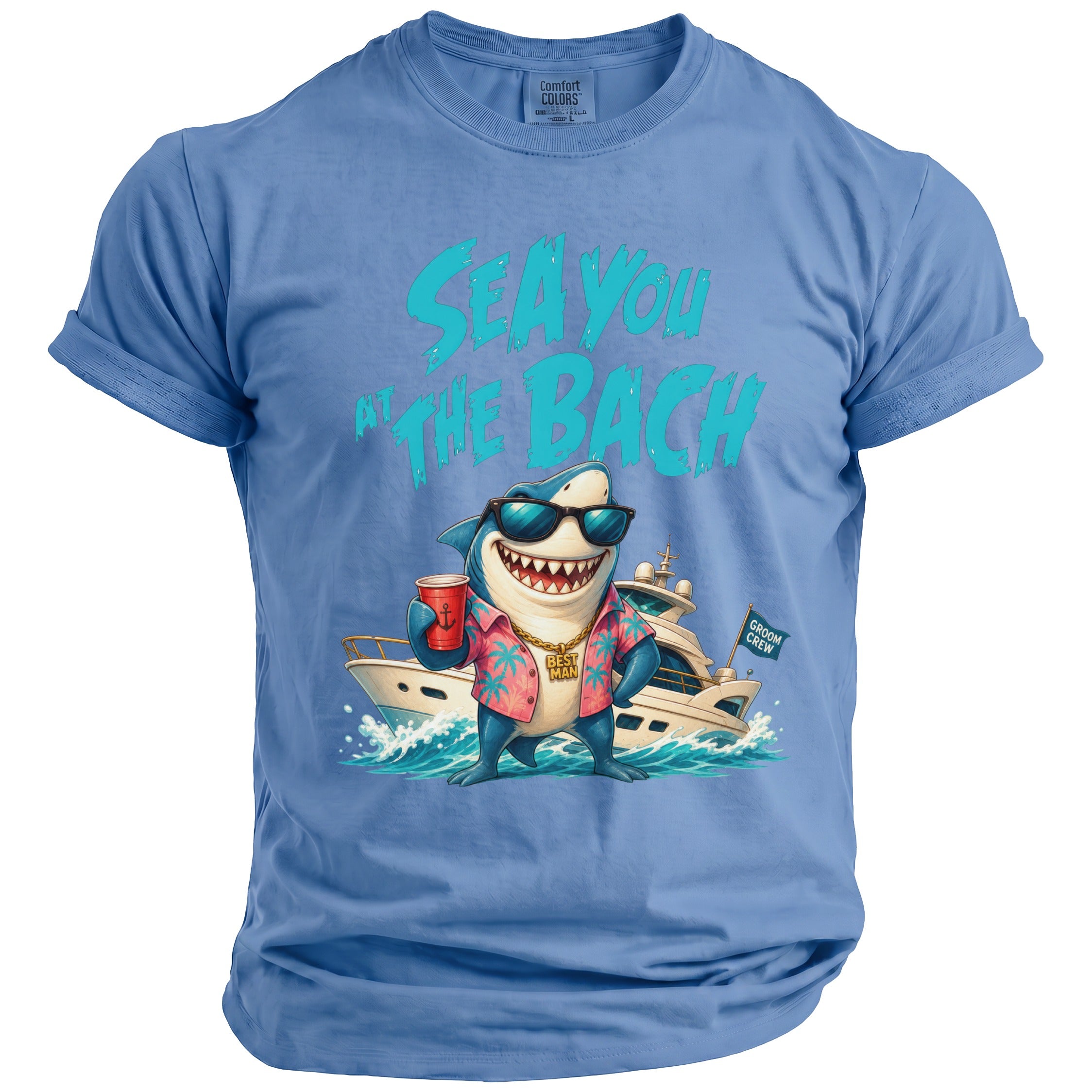 A light blue t-shirt featuring a shark wearing sunglasses, a floral shirt, and a gold chain that says "BEST MAN" in front of a yacht, with the text "SEA YOU AT THE BACH" above.