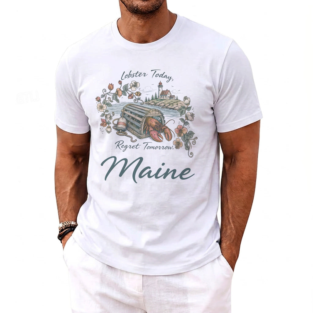 White t-shirt with a graphic of a lobster in a trap, lighthouse, and floral wreath with text.