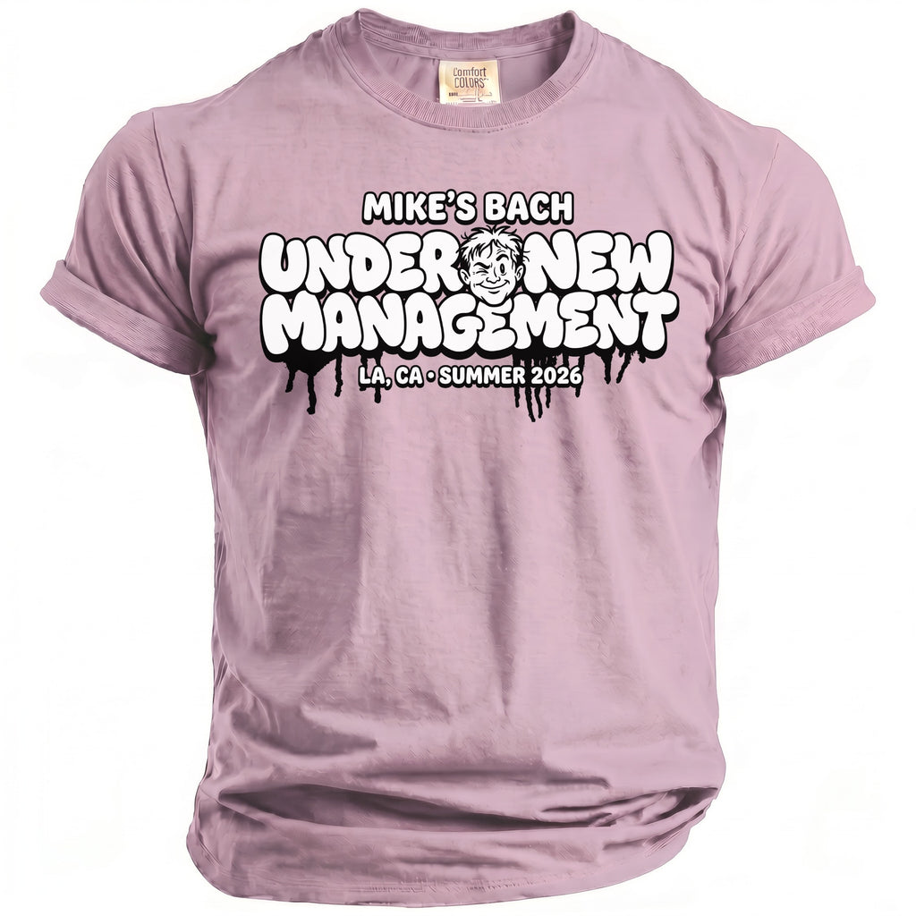 Lilac t-shirt with "Mike's Bach Under New Management" graphic and cartoon face.