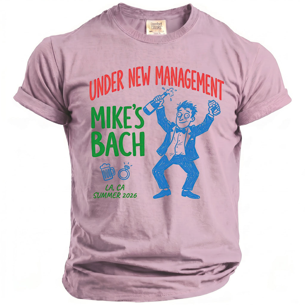 Pink t-shirt with "Under New Management Mike's Bach" and cartoon celebrating.
