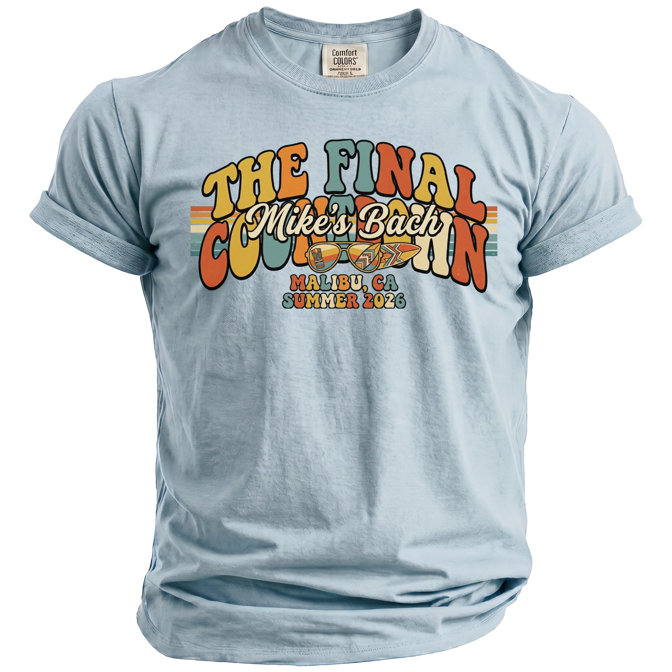 Light blue t-shirt with "The Final Mike's Bach" graphic, sunglasses, and surfboard.