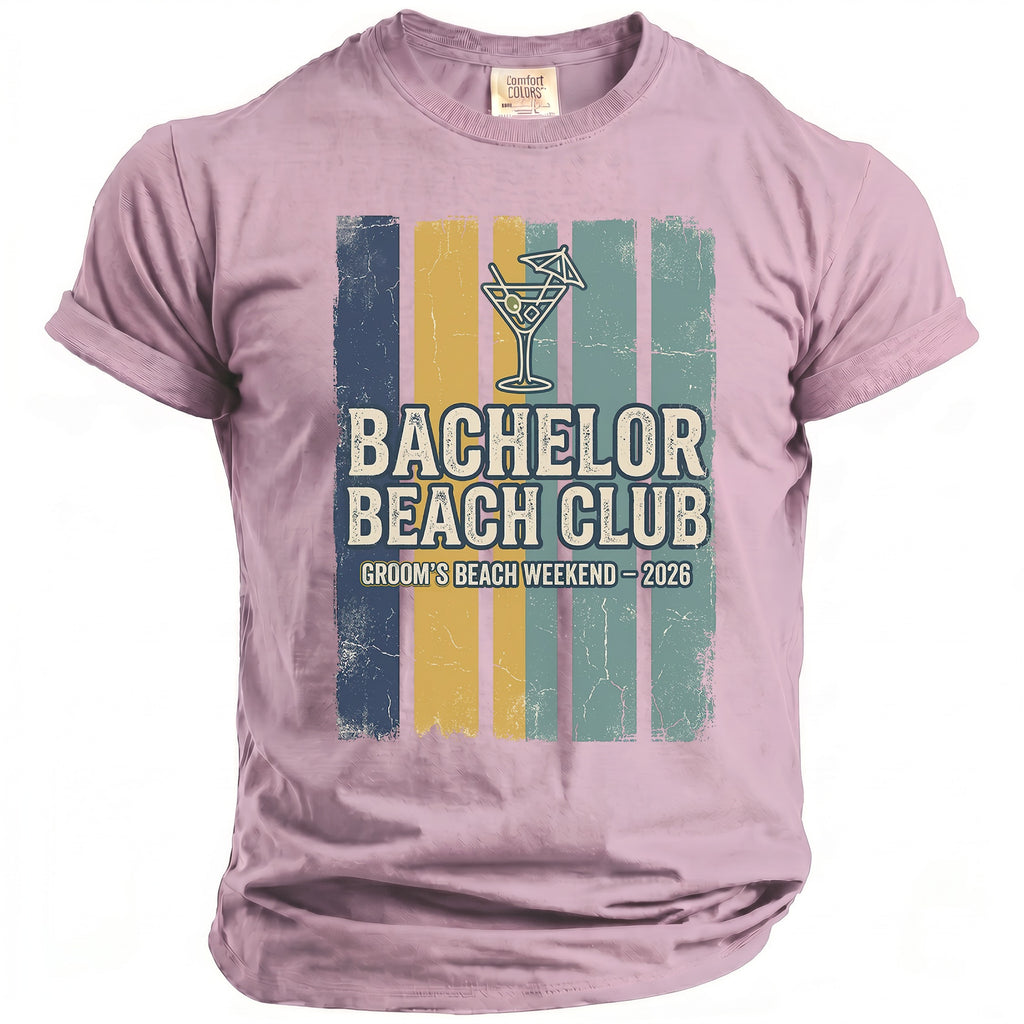 Pink t-shirt with "Bachelor Beach Club Groom's Beach Weekend 2026" graphic.