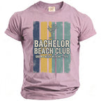 Pink t-shirt with "Bachelor Beach Club Groom's Beach Weekend 2026" graphic.