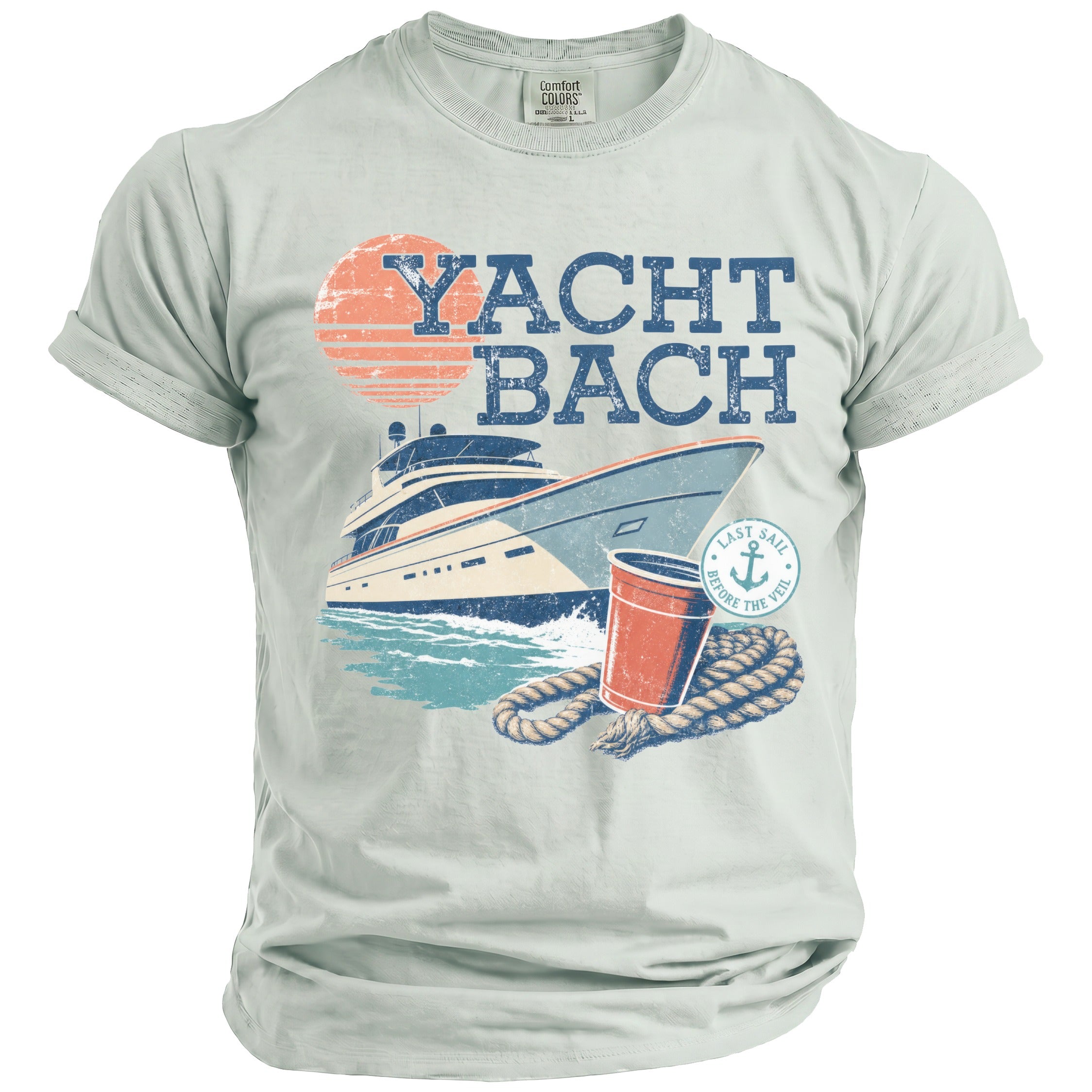 A light-colored t-shirt featuring a retro graphic of a yacht, a sunset, a red cup, coiled rope, and the text YACHT BACH.