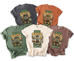 Five t-shirts in various colors featuring a graphic of a man with beers and text.