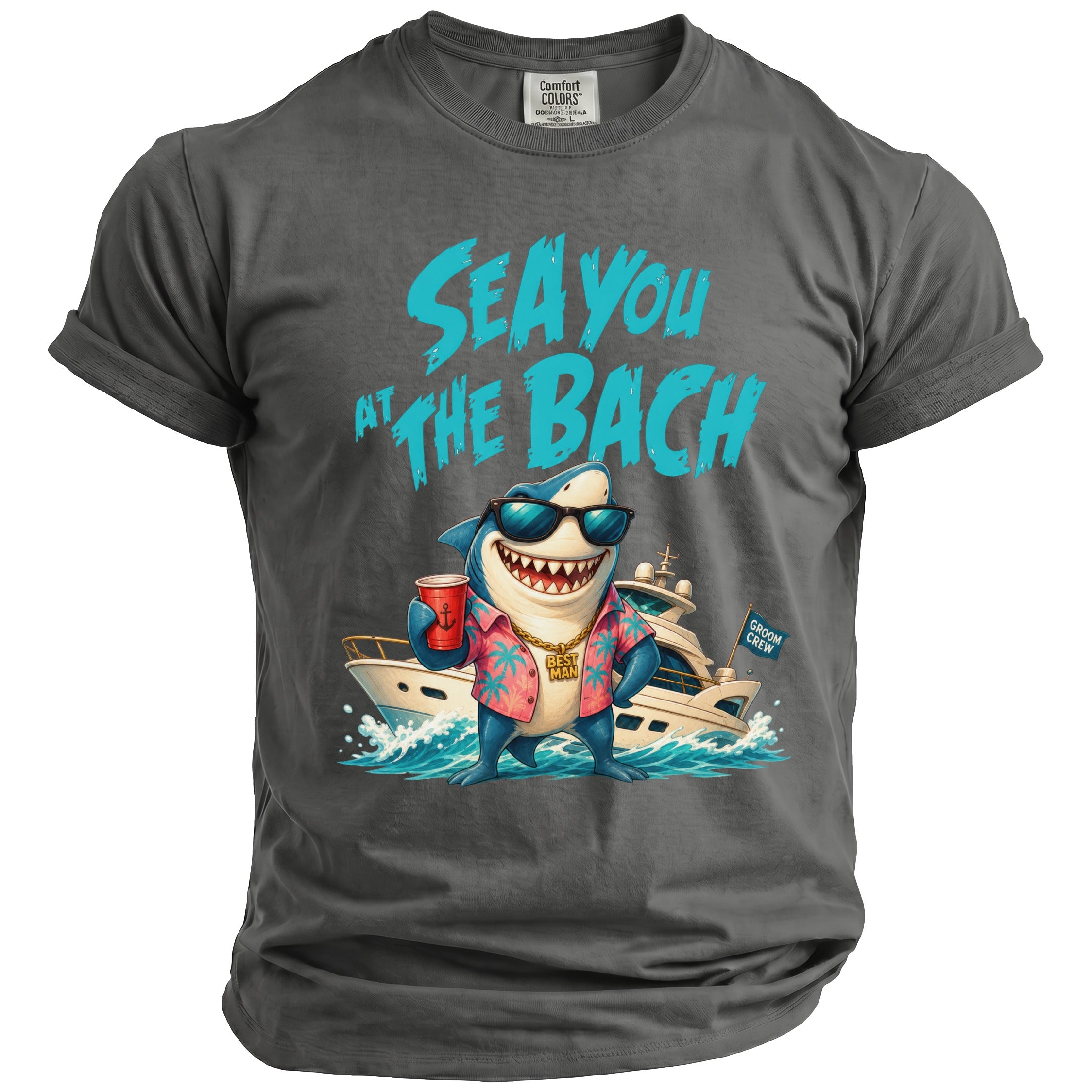 A charcoal grey t-shirt featuring a shark wearing sunglasses, a floral shirt, and a gold chain, with the text SEA YOU AT THE BACH.