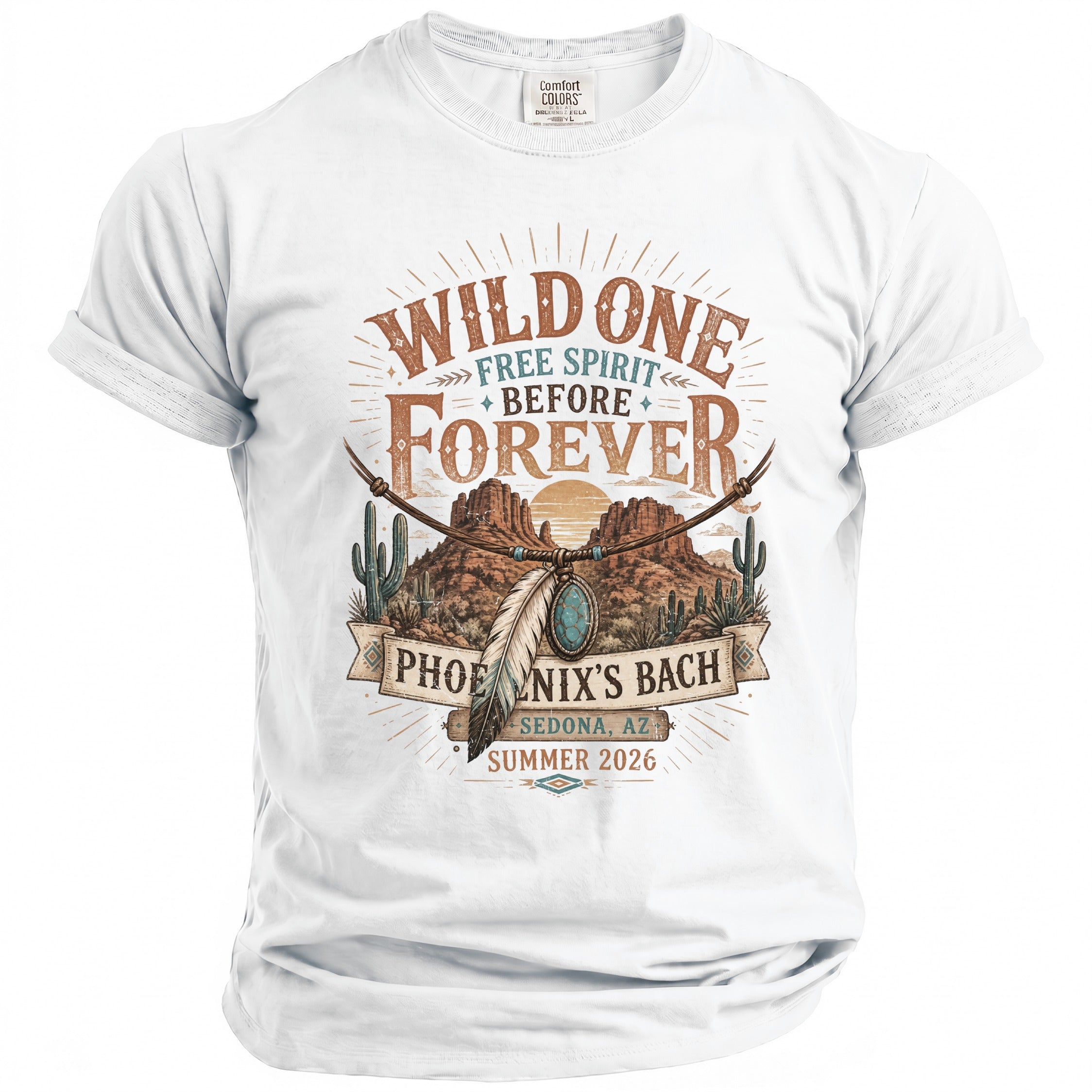 White t-shirt with graphic art featuring desert landscape, text "Wild One Free Spirit Before Forever Phoenix's Bach Sedona, AZ Summer 2026".