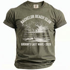 Olive green t-shirt with "BACHELOR BEACH CLUB" and "GROOM'S LAST WAVE 2026" text.