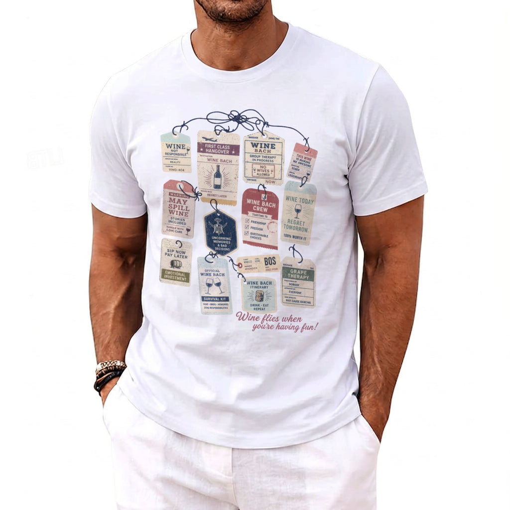 White t-shirt with wine-themed luggage tag graphic and "Wine flies when you're having fun!" text.